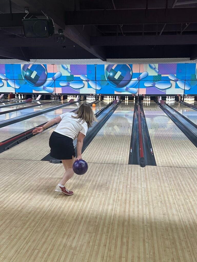 A woman bowling at Universal Lanes Warren